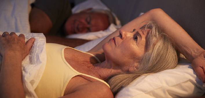 worried-senior-woman-in-bed-at-night-suffering-with-insomnia-picture-id864362760_AL